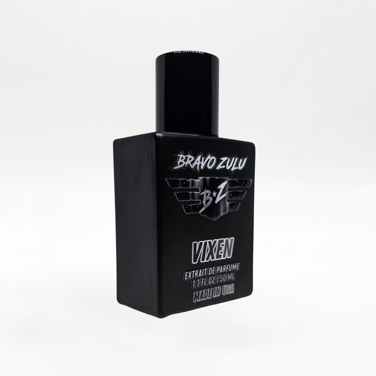 Bravo Zulu Flagship Soap Company VIXEN Extrait de Parfum bottle, angled three-quarter view, showing the heavy matte black glass bottle with black cap and silver BRAVO ZULU B★Z winged logo, VIXEN name, Extrait de Parfume 1.7 FL OZ / 50 ML, and Made in USA text, on a seamless white studio background.