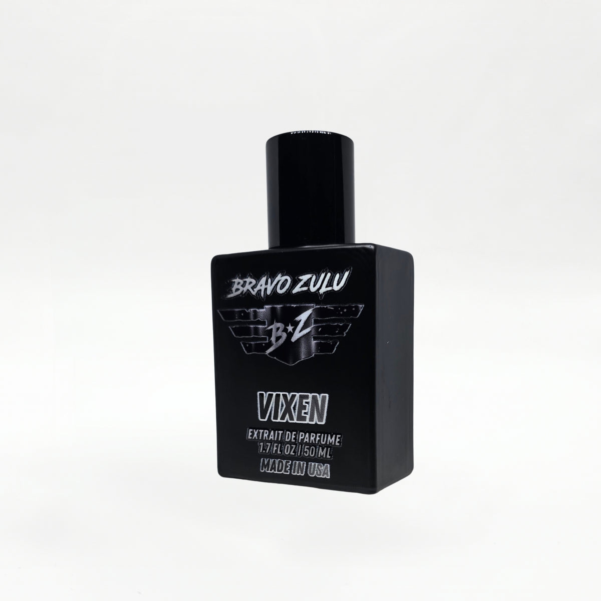 Close angled product shot of the Bravo Zulu VIXEN Extrait de Parfum bottle by Flagship Soap Company, showing the matte black glass bottle and black cap with silver BRAVO ZULU B★Z winged logo and VIXEN branding, set against a seamless white studio background.