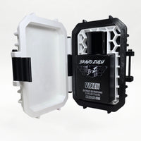 Bravo Zulu VIXEN Extrait de Parfum by Flagship Soap Company shown docked inside its open rugged tactical case, the matte black glass bottle secured in the black honeycomb interior insert opposite the empty white lid, on a seamless white studio background.