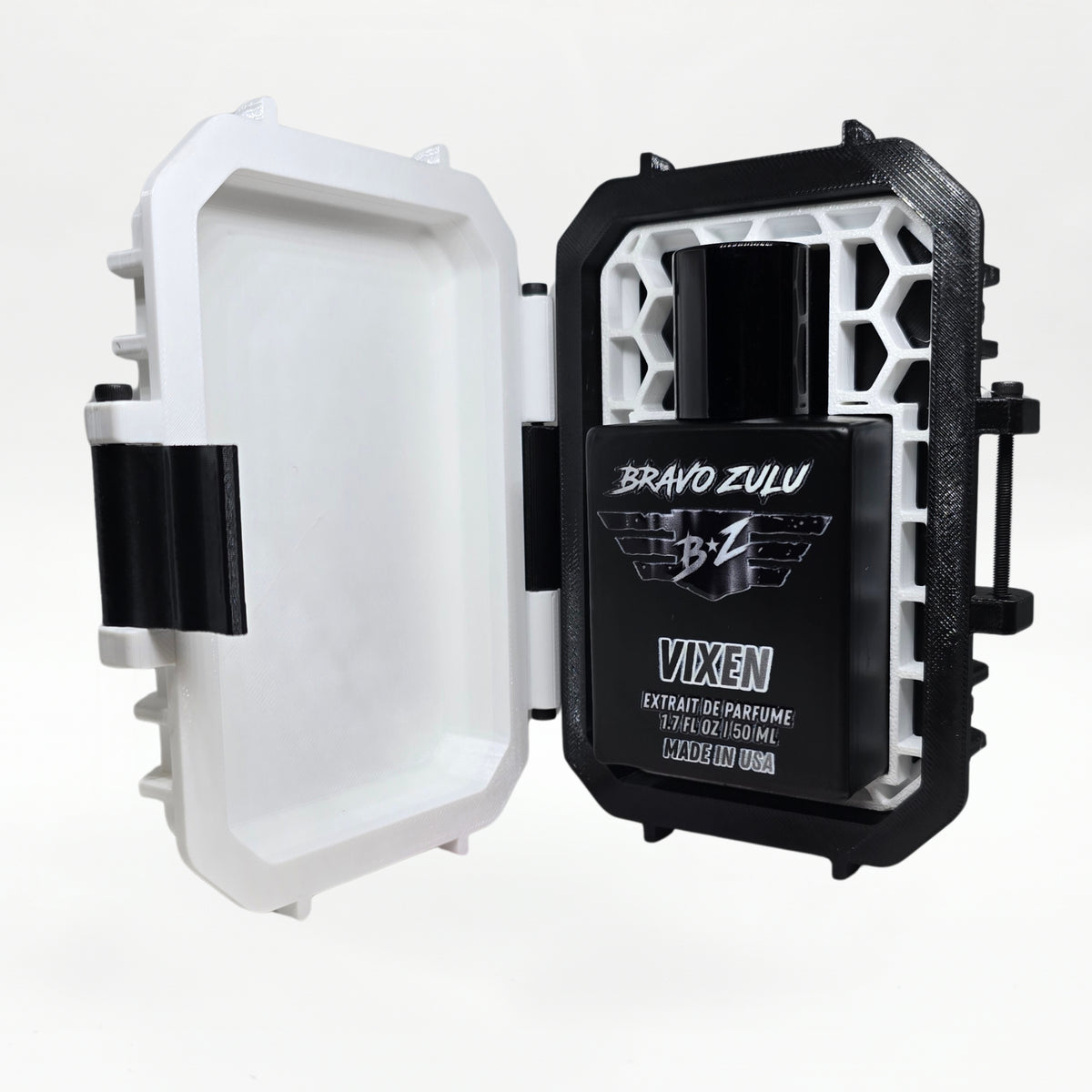 Bravo Zulu VIXEN Extrait de Parfum by Flagship Soap Company shown docked inside its open rugged tactical case, the matte black glass bottle secured in the black honeycomb interior insert opposite the empty white lid, on a seamless white studio background.