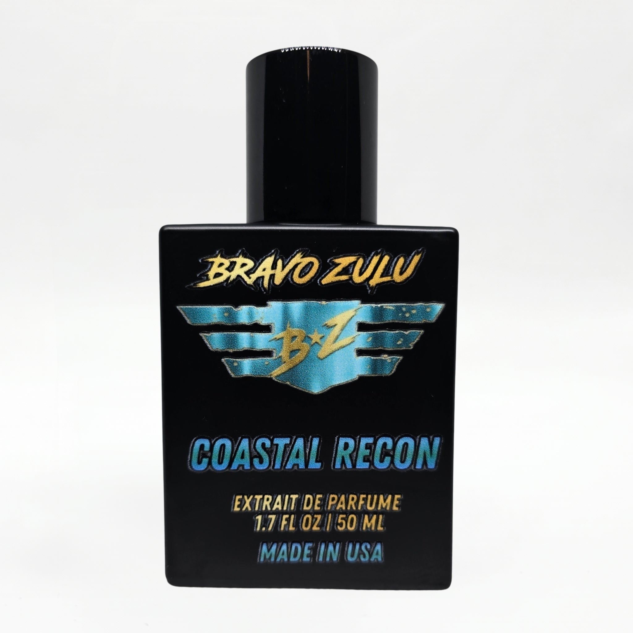 Front-facing studio product shot of Bravo Zulu COASTAL RECON Extrait de Parfum by Flagship Soap Company. The heavy matte black glass bottle with matching black cap is centered on a clean white background, displaying the turquoise-and-gold BRAVO ZULU B★Z winged logo, COASTAL RECON name, Extrait de Parfume 1.7 FL OZ / 50 ML, and Made in USA text.