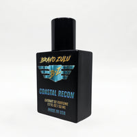 Alternate angled studio shot of the Bravo Zulu COASTAL RECON Extrait de Parfum bottle by Flagship Soap Company, rotated to show the turquoise-and-gold BRAVO ZULU B★Z winged logo and COASTAL RECON name from a different perspective, on a seamless white studio background.