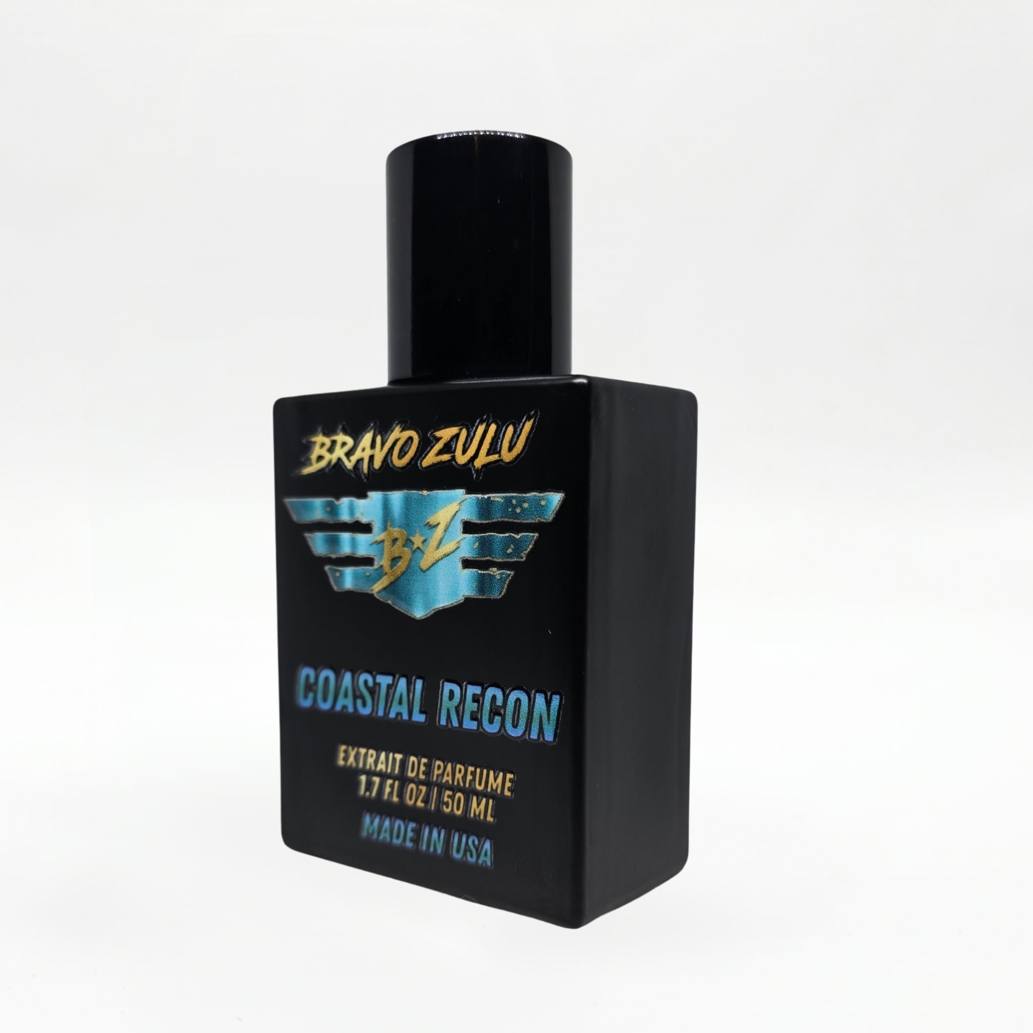 Alternate angled studio shot of the Bravo Zulu COASTAL RECON Extrait de Parfum bottle by Flagship Soap Company, rotated to show the turquoise-and-gold BRAVO ZULU B★Z winged logo and COASTAL RECON name from a different perspective, on a seamless white studio background.