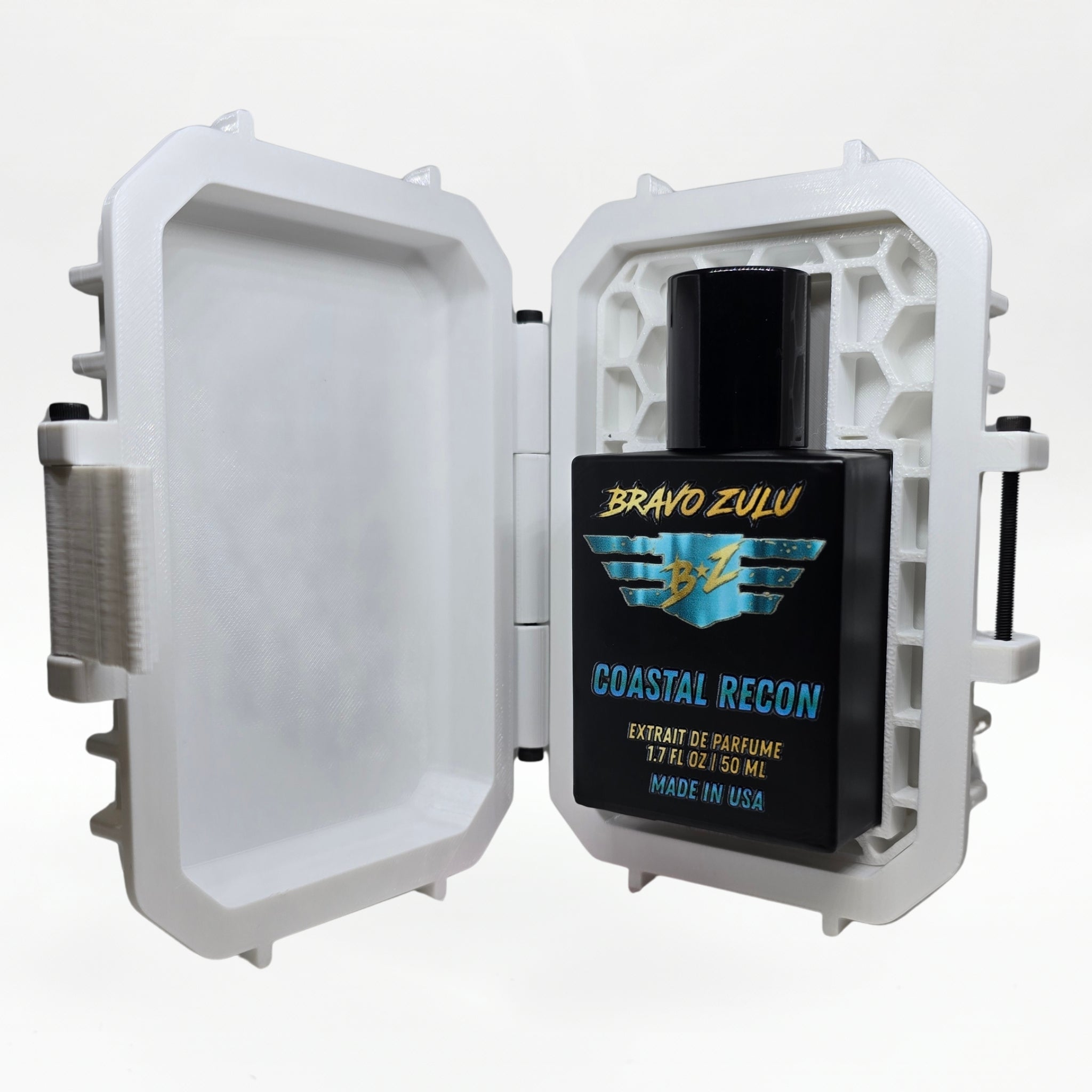 Bravo Zulu COASTAL RECON Extrait de Parfum by Flagship Soap Company shown docked inside its open white rugged tactical case, the matte black glass bottle secured in the honeycomb interior insert opposite the empty white lid, on a seamless white studio background.