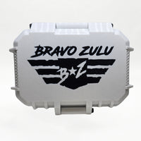 Closed white rugged tactical travel case for Bravo Zulu COASTAL RECON Extrait de Parfum by Flagship Soap Company, front view showing the black BRAVO ZULU B★Z winged logo on the case exterior, on a seamless white studio background.