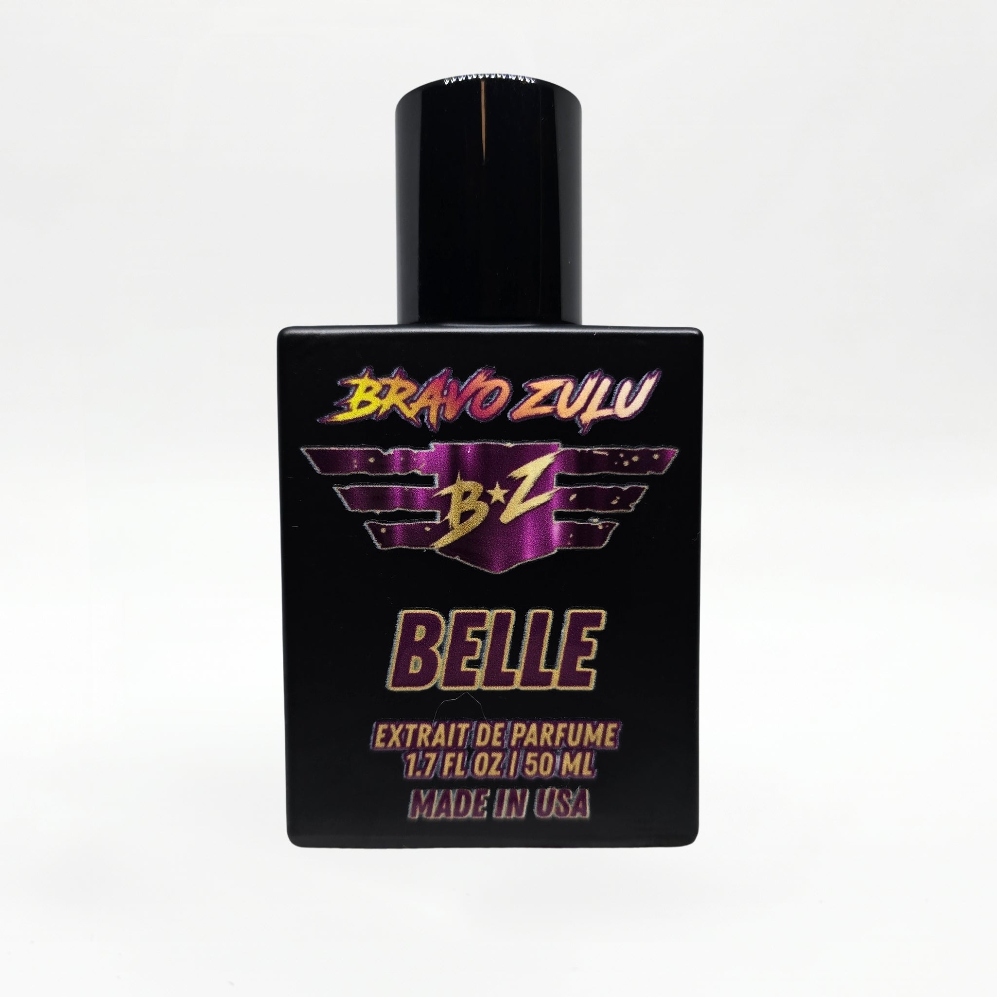 Front-facing studio product shot of Bravo Zulu BELLE Extrait de Parfum by Flagship Soap Company. The heavy matte black glass bottle with matching black cap is centered on a clean white background, displaying the maroon-and-gold BRAVO ZULU B★Z winged logo, BELLE name, Extrait de Parfume 1.7 FL OZ / 50 ML, and Made in USA text.