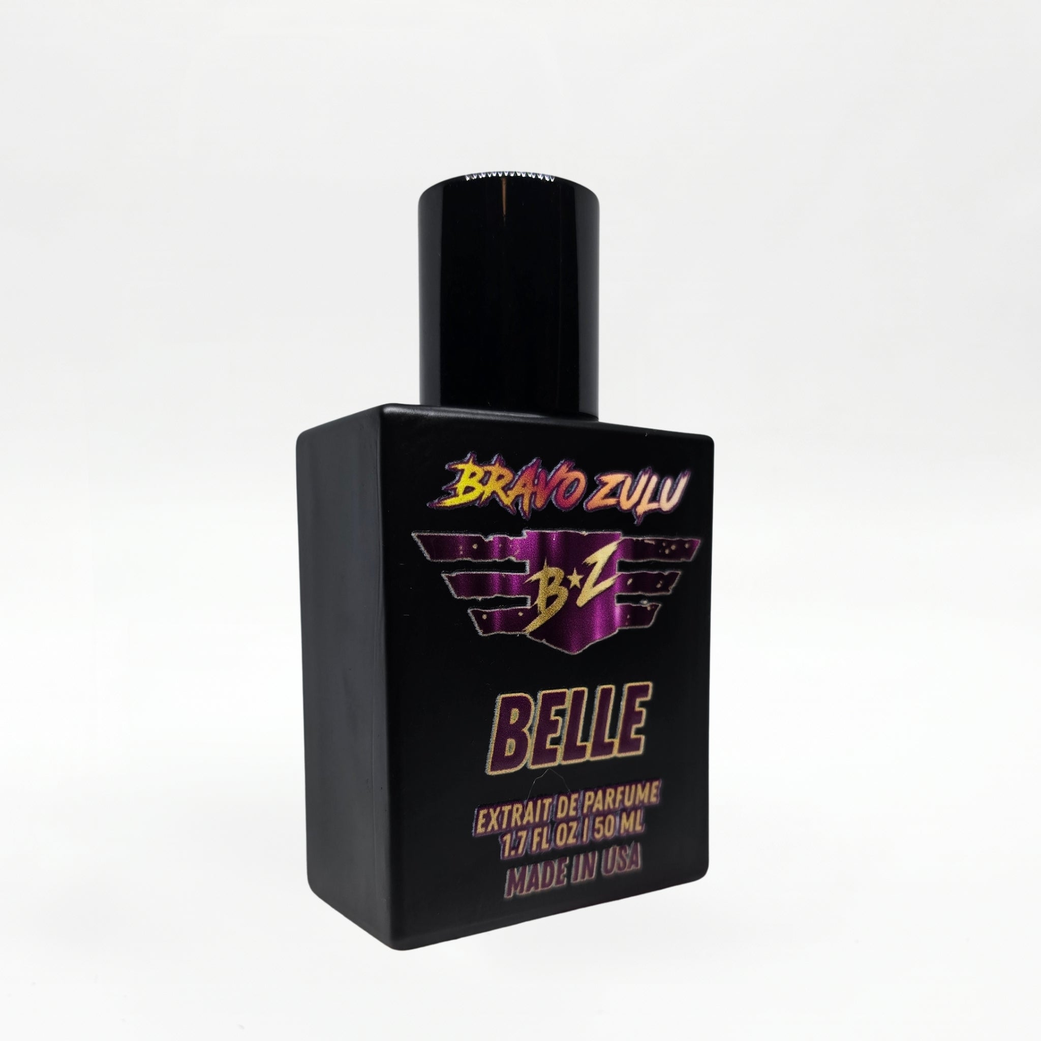 Angled studio shot of the Bravo Zulu BELLE Extrait de Parfum bottle by Flagship Soap Company, showing the matte black glass bottle and black cap with maroon-and-gold BRAVO ZULU B★Z winged logo and BELLE branding, set against a seamless white studio background.