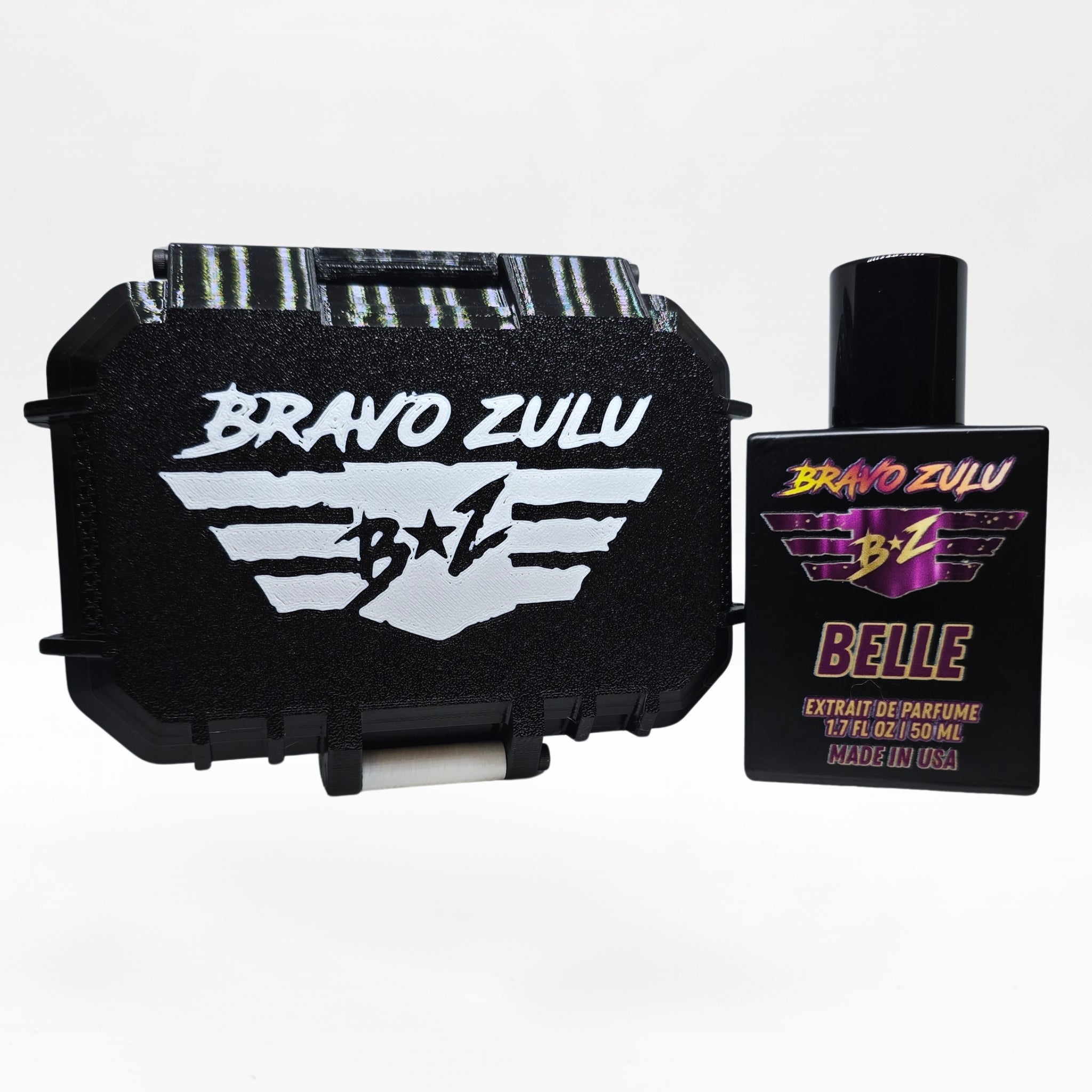 Bravo Zulu BELLE Extrait de Parfum by Flagship Soap Company displayed side by side with its closed black rugged tactical case featuring the white BRAVO ZULU B★Z winged logo, on a clean white studio background.