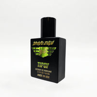 Angled studio shot of the Bravo Zulu TIPSY Extrait de Parfum bottle by Flagship Soap Company, showing the matte black glass bottle and black cap with lime-green BRAVO ZULU B★Z winged logo and TIPSY branding, set against a seamless white studio background.