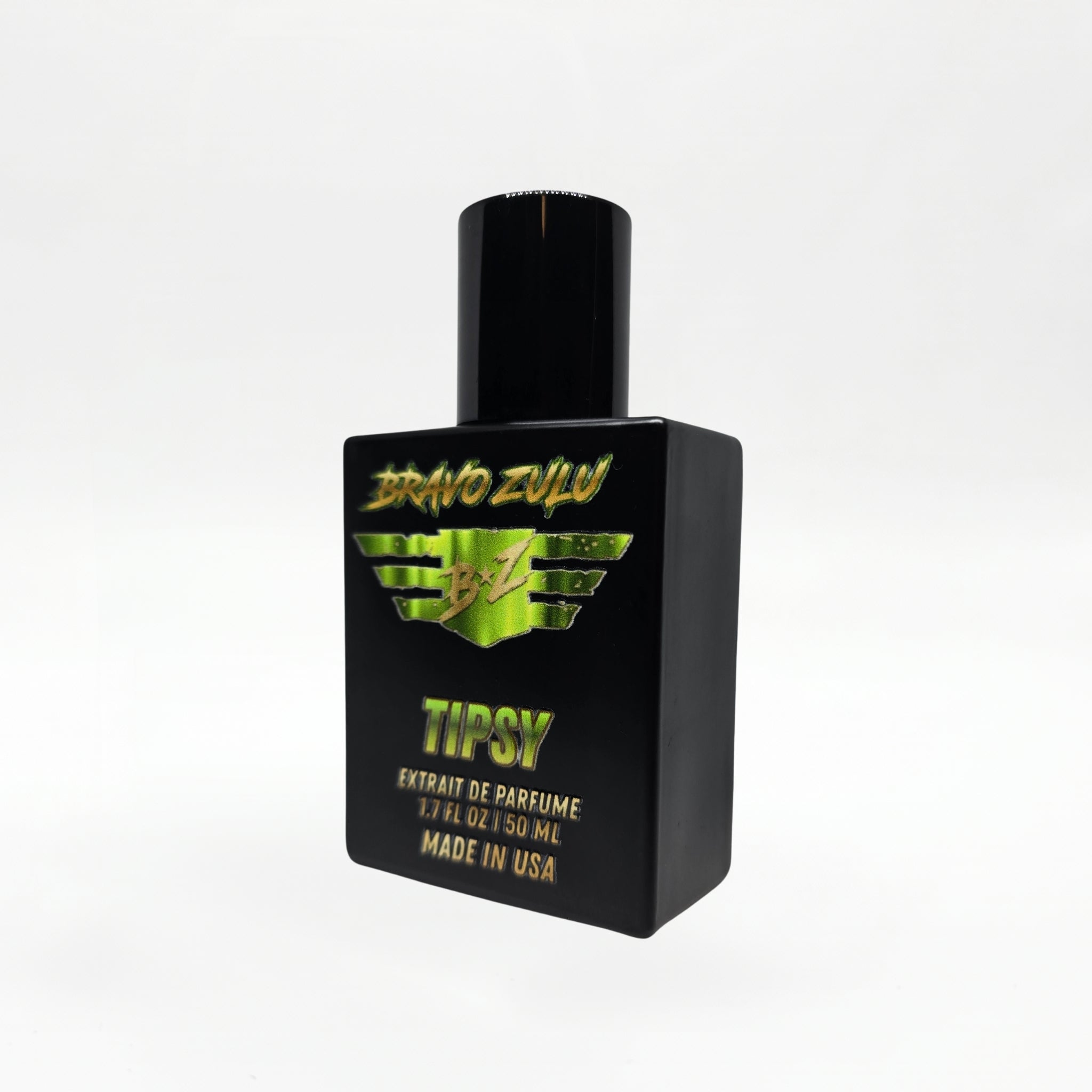 Angled studio shot of the Bravo Zulu TIPSY Extrait de Parfum bottle by Flagship Soap Company, showing the matte black glass bottle and black cap with lime-green BRAVO ZULU B★Z winged logo and TIPSY branding, set against a seamless white studio background.