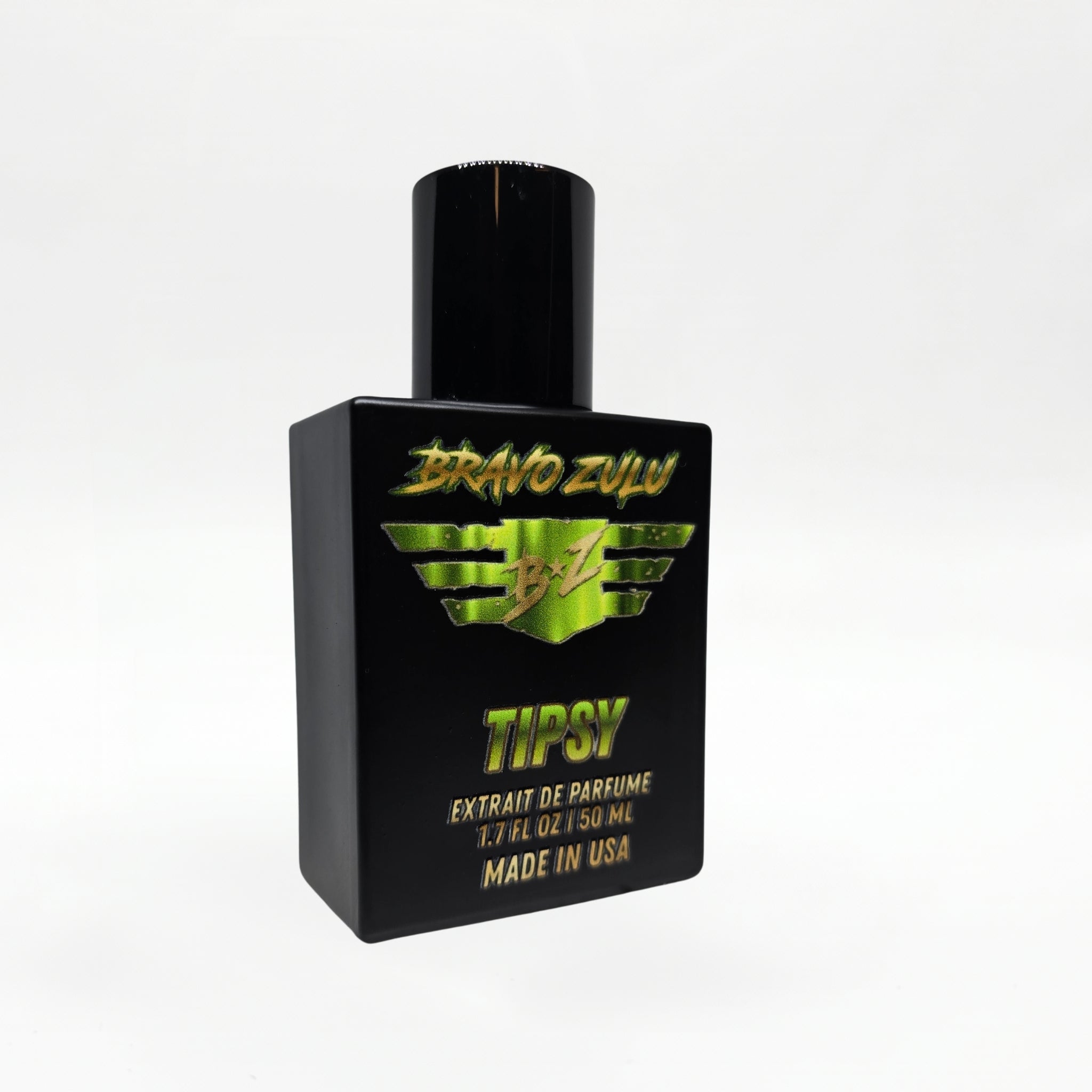 Bravo Zulu TIPSY Extrait de Parfum bottle by Flagship Soap Company balanced on top of its closed black rugged tactical case, the matte black glass bottle displaying the lime-green BRAVO ZULU B★Z winged logo and TIPSY name, on a seamless white studio background.