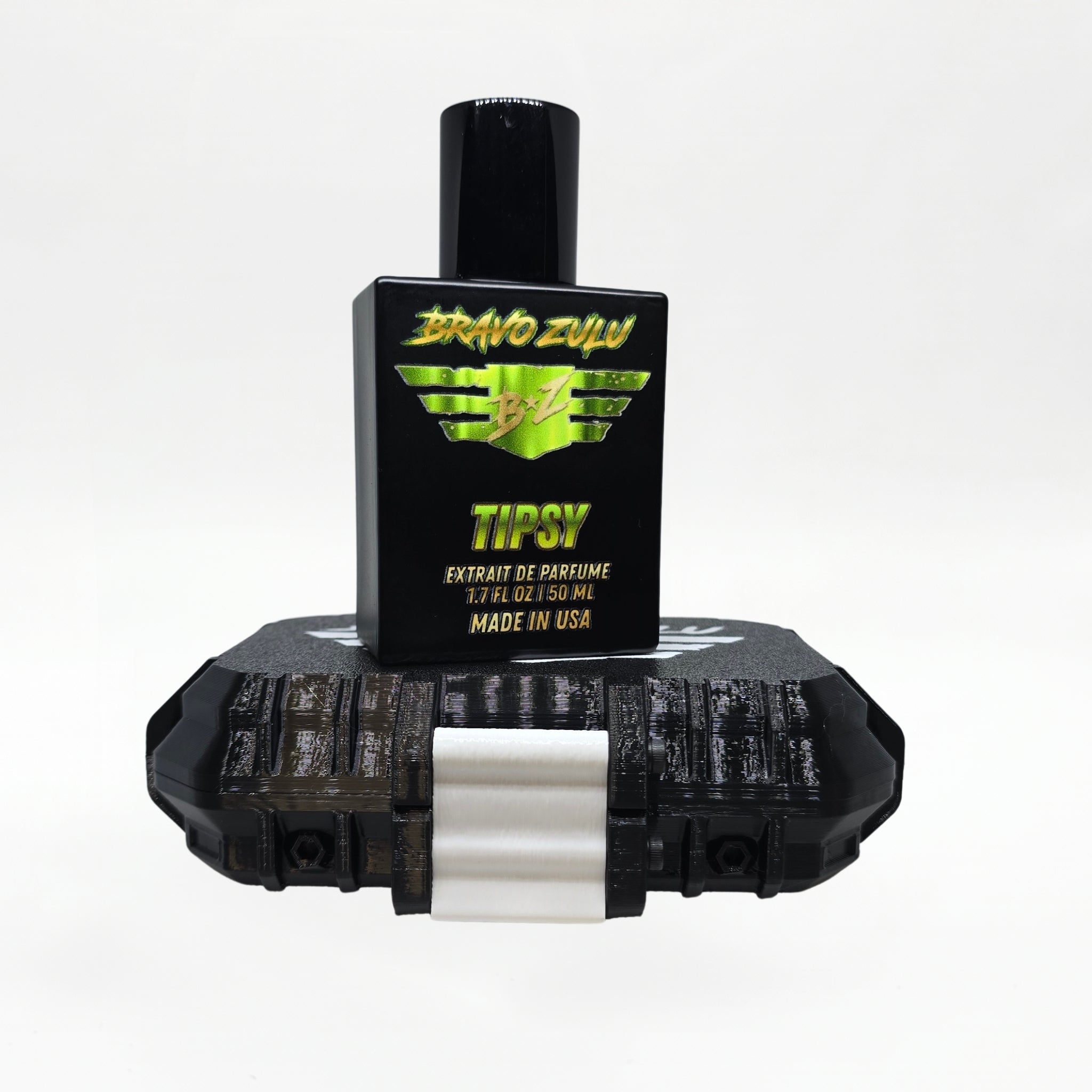 Bravo Zulu TIPSY Extrait de Parfum by Flagship Soap Company shown docked inside its open black rugged tactical case, the matte black glass bottle secured in the honeycomb interior insert opposite the white foam-lined lid, on a seamless white studio background.