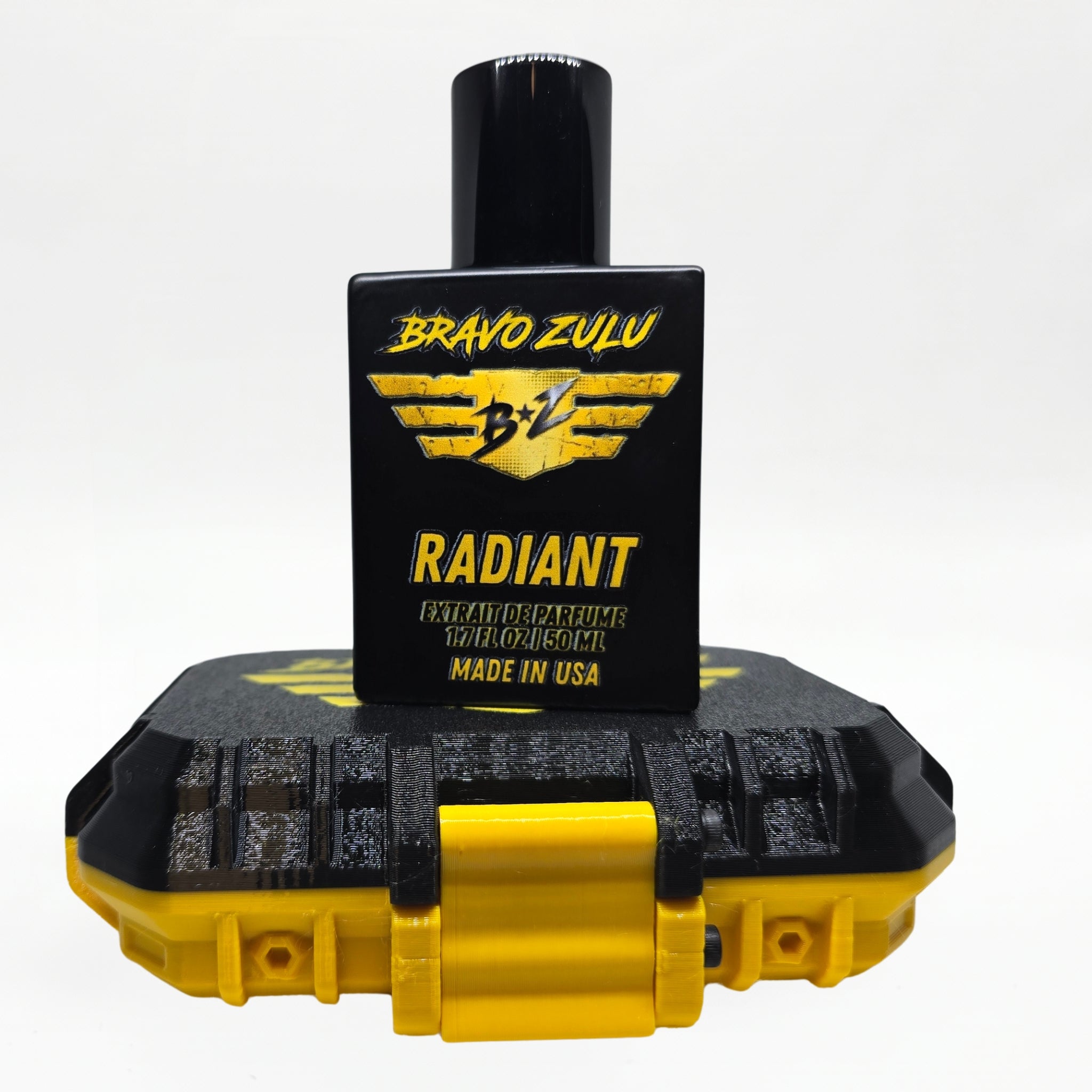 Bravo Zulu RADIANT Extrait de Parfum by Flagship Soap Company shown docked inside its open yellow rugged tactical case, the matte black glass bottle secured in the black honeycomb interior insert opposite the empty lid, on a seamless white studio background.