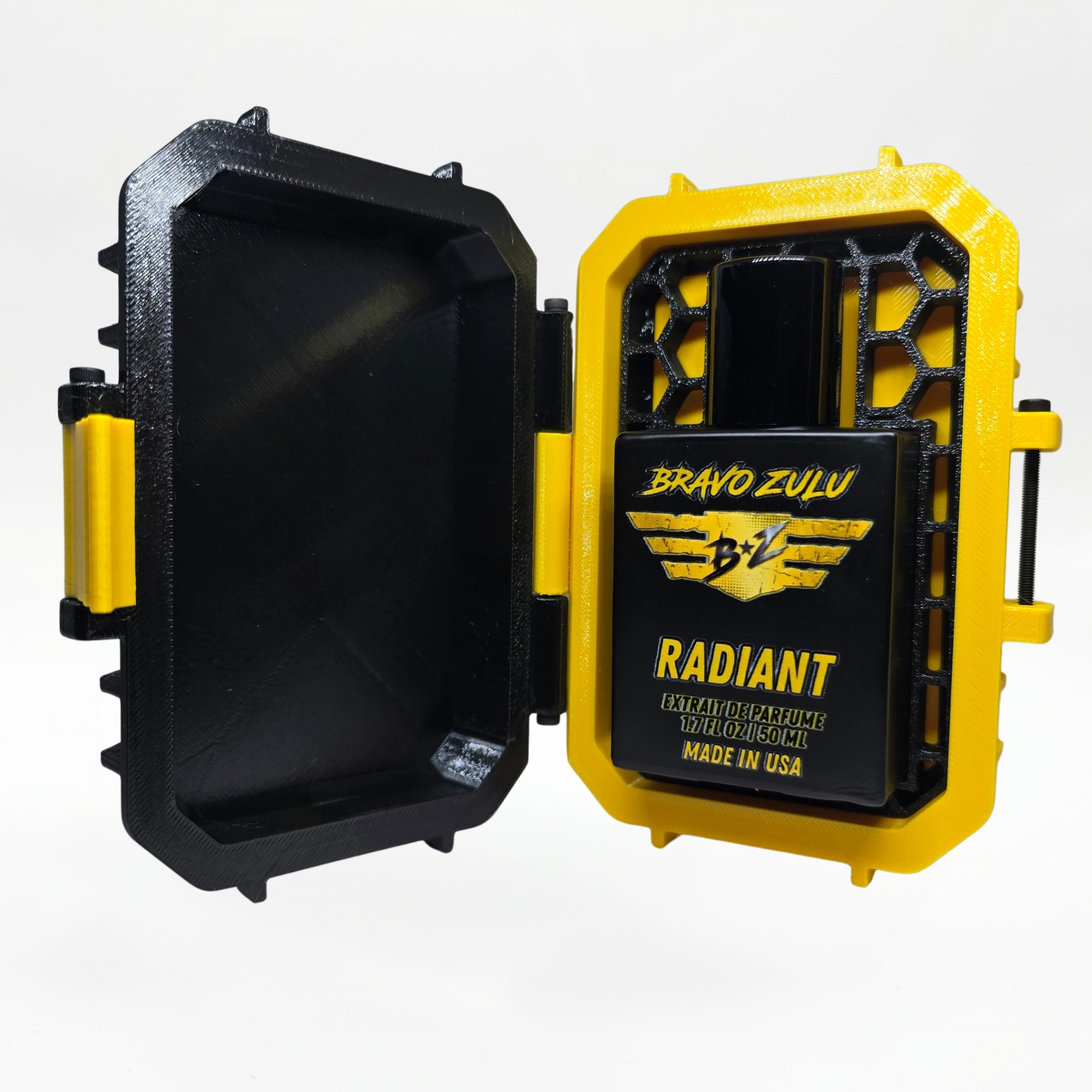 Closed black-and-yellow rugged tactical travel case for Bravo Zulu RADIANT Extrait de Parfum by Flagship Soap Company, front view showing the gold BRAVO ZULU B★Z winged logo on the case exterior, on a seamless white studio background.