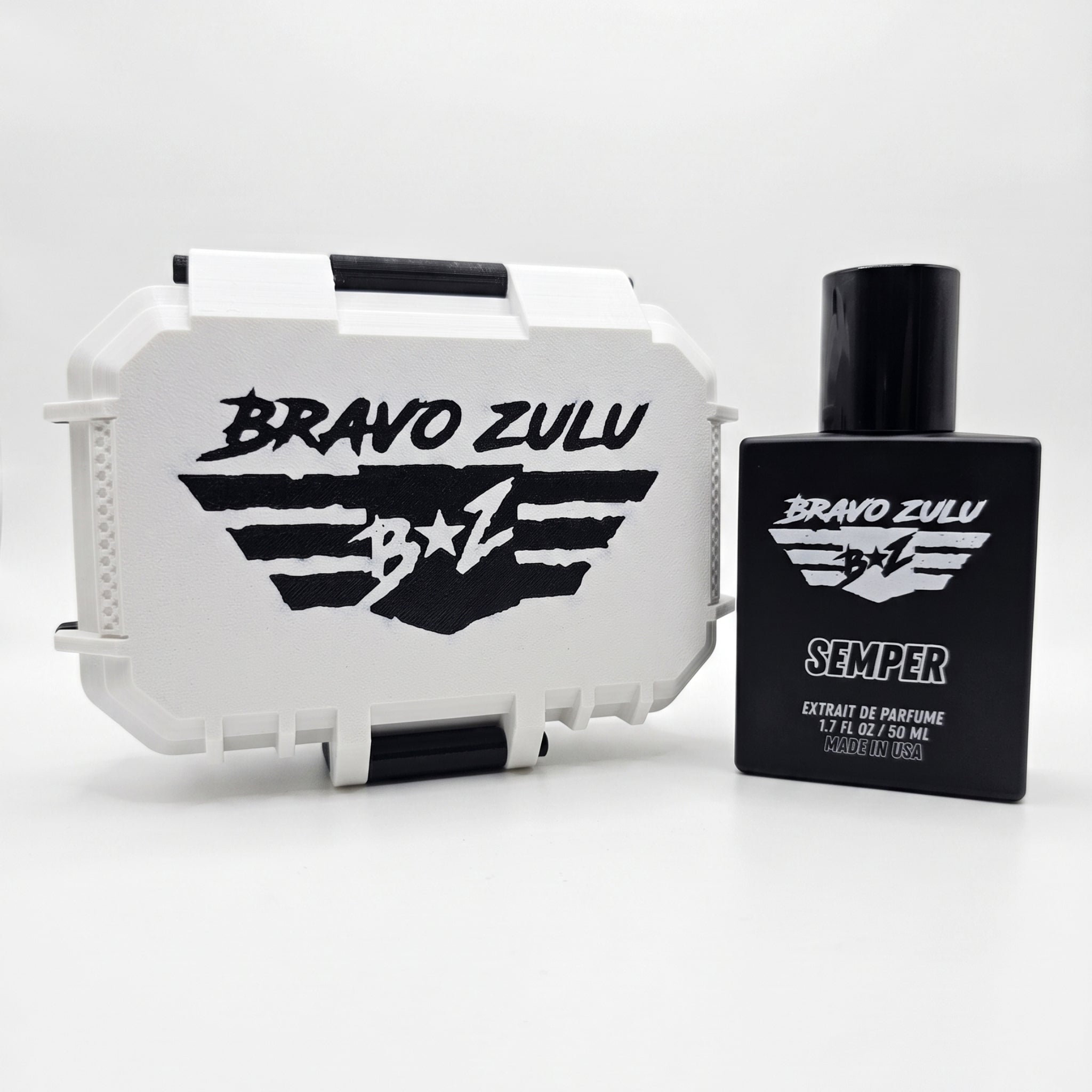 A side-by-side e-commerce product shot of SEMPER Extrait de Parfum by Bravo Zulu on a seamless white background. On the right stands the heavy tactical matte black glass bottle, featuring crisp white flight-wing branding. On the left is the matching custom-engineered, rugged protective case finished in clean Vanguard White with aggressive matte black contrast accents and a bold, black flight-wing logo. This elite, American-built cologne represents a heavy-duty standard of quality engineered for a commanding