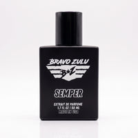 A crisp e-commerce product packshot of SEMPER Extrait de Parfum by Bravo Zulu, centered on a seamless white background with a clear reflection below. The heavy tactical matte black glass bottle prominently features sharp white branding, a flight-wing B+Z shield logo, and bold text. This premium, American-built cologne represents a fiercely elite standard of quality, engineered with a commanding 30% concentration for maximum permanence.