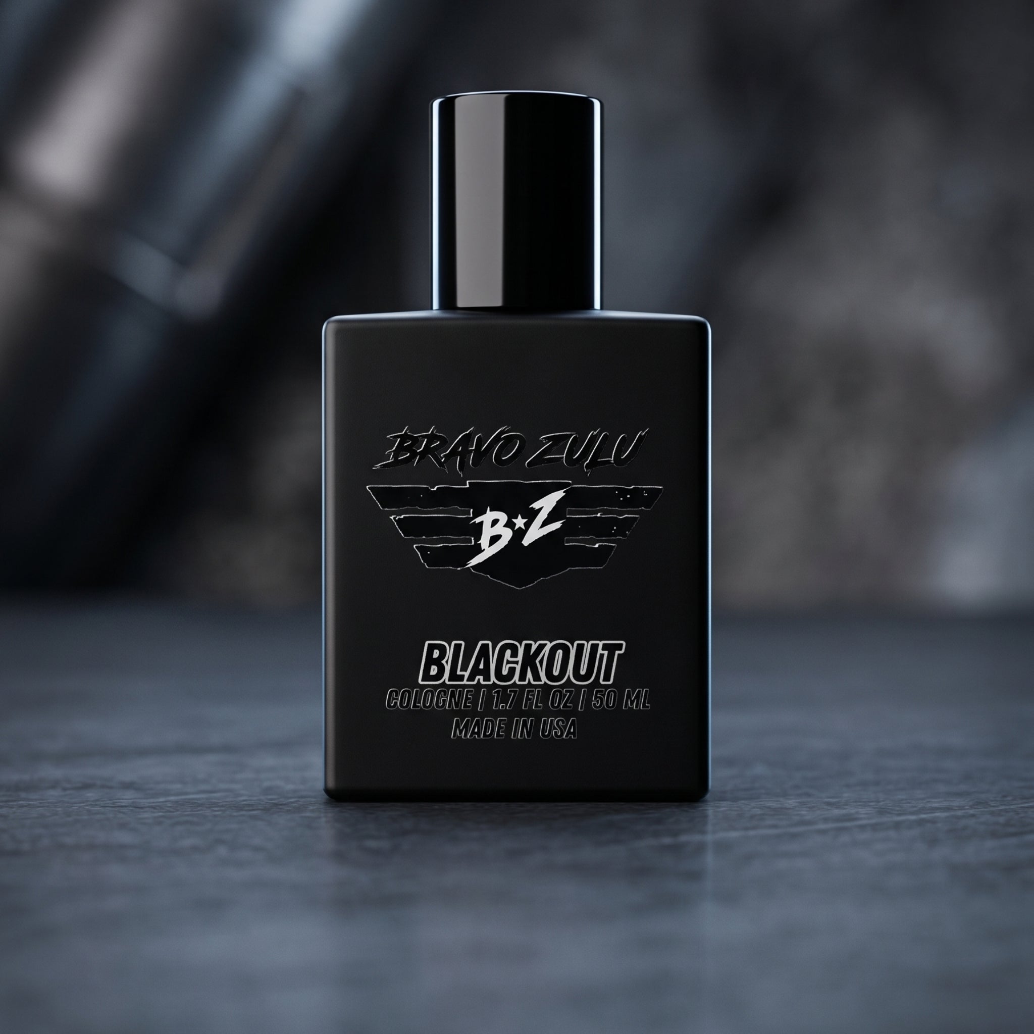 A professional product shot features the "BRAVO ZULU BLACKOUT" cologne, an aggressive, tactical masterpiece engineered for the men who defend the perimeter and hunt. Housed in a heavy, tactical matte black glass bottle built to block UV light, it presents an elite, monochromatic aesthetic designed to silenty take over. The bottle stands against a dark, moody background of rugged woods and deep shadows, reflecting the pitch-black musk, raw exotic woods, and gritty winter spices that form its unyielding, dang