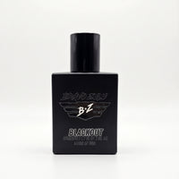 A product shot of the BRAVO ZULU BLACKOUT Extrait de Parfum cologne bottle from Flagship Soap Company, an American-Built premium juice. This square, tactical matte black glass bottle, designed to block UV light and house the true 30% oil concentration, features clean white text and logos. 'BRAVO ZULU' stylized text is above the signature winged 'B+Z' logo. Below the large 'BLACKOUT' text is smaller detail: 'EXTRAIT DE PARFUM | 1.35 FL OZ | 40 mL' and 'Made in the USA'. The 40ml compact footprint bottle is u