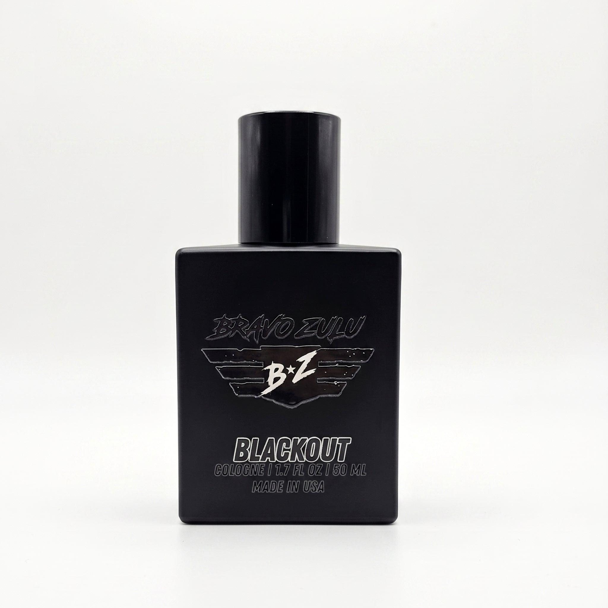 A product shot of the BRAVO ZULU BLACKOUT Extrait de Parfum cologne bottle from Flagship Soap Company, an American-Built premium juice. This square, tactical matte black glass bottle, designed to block UV light and house the true 30% oil concentration, features clean white text and logos. 'BRAVO ZULU' stylized text is above the signature winged 'B+Z' logo. Below the large 'BLACKOUT' text is smaller detail: 'EXTRAIT DE PARFUM | 1.35 FL OZ | 40 mL' and 'Made in the USA'. The 40ml compact footprint bottle is u