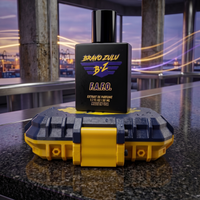 Tactical reality product shot of F.A.F.O. Extrait de Parfum cologne by Flagship Soap Company. The heavy matte black glass bottle features a purple and yellow Bravo Zulu BZ logo and sits atop its custom-engineered rugged protective case, finished in high-visibility Tactical Blue and Strike Yellow contrast accents with realistic water droplets. The hardware is displayed on a polished black granite surface inside a modern industrial room, showcasing an uncompromising action aesthetic with a seaport and twiligh