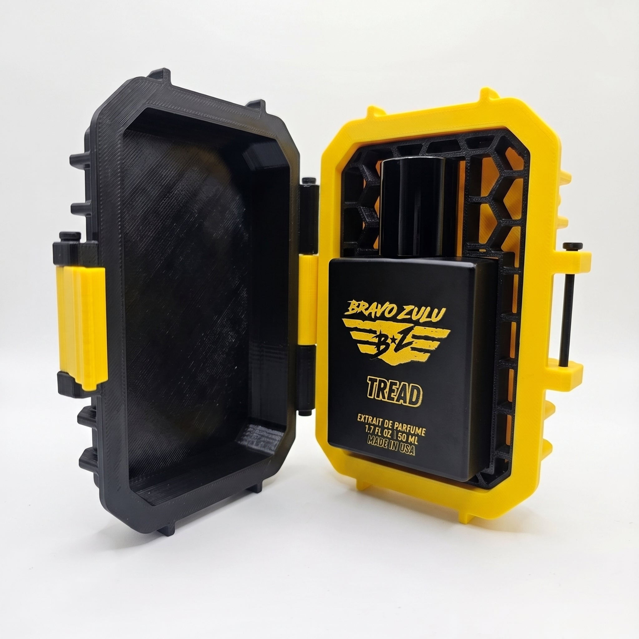 Flagship Soap Company TREAD Extrait de Parfum cologne bottle showcased inside its open, custom tactical case against a clean white background. Features the matte black glass bottle nestled into a high-visibility yellow protective dock with a black geometric honeycomb matrix, highlighting an elite and rugged unboxing presentation.