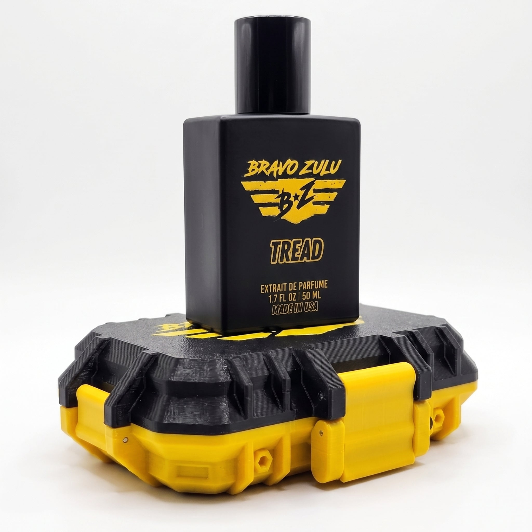 Flagship Soap Company TREAD Extrait de Parfum tactical matte black cologne bottle stacked on top of its closed custom black and yellow tactical hardware case. Both items feature the high-contrast yellow Bravo Zulu brand logo, displayed on a clean white background.