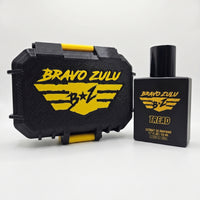 Flagship Soap Company TREAD Extrait de Parfum cologne bottle shown alongside its custom tactical case on a seamless white background. Both the matte black glass fragrance bottle and the rugged, heavy-duty protective case feature the striking yellow Bravo Zulu brand logo, emphasizing an aggressive, tactical presentation.