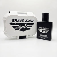 A professional product photograph showcasing the Bravo Zulu VENDETTA fragrance and its gift-ready custom case arranged side-by-side on a clean white background.

On the right stands the heavy, tactical matte black glass bottle designed to block out UV light and protect the integrity of the premium 30% Extrait de Parfum oils inside. The front of the bottle features silver-embossed branding with the "BRAVO ZULU B★Z" winged shield insignia and the bold title text "VENDETTA," detailed with "COLOGNE | 1.7 FL OZ 