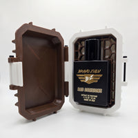 Product shot of Bravo Zulu BAD DECISIONS 40ml men's cologne by Flagship Soap Company on a seamless white background. The tactical matte black glass bottle is nestled inside its open custom-engineered Bourbon Brown and white protective case, built to secure this high-performance, 30% oil concentration fragrance featuring warm notes of aged barrel-proof bourbon, charred oak wood, and smooth spice.