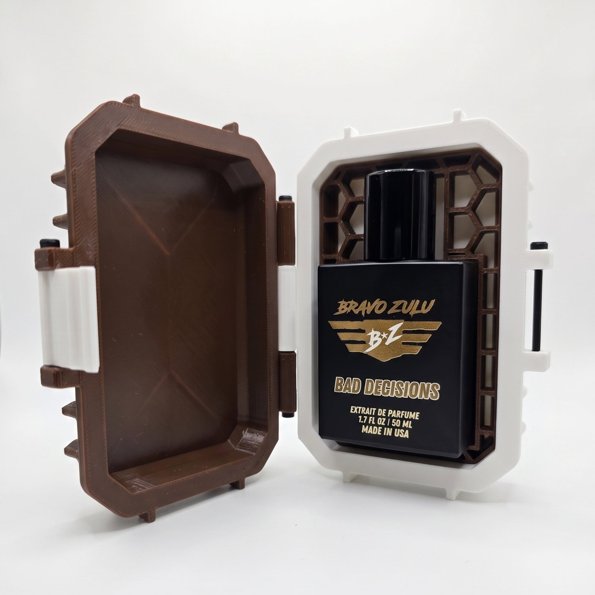 Product shot of Bravo Zulu BAD DECISIONS 40ml men's cologne by Flagship Soap Company on a seamless white background. The tactical matte black glass bottle is nestled inside its open custom-engineered Bourbon Brown and white protective case, built to secure this high-performance, 30% oil concentration fragrance featuring warm notes of aged barrel-proof bourbon, charred oak wood, and smooth spice.