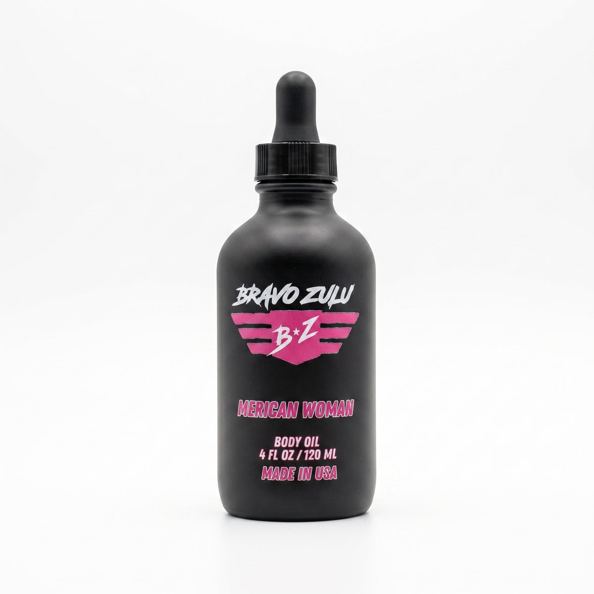 Bravo Zulu Merican Woman Body Oil dropper bottle on a sandy beach with an American flag and ocean waves in the background, pink Bravo Zulu B★Z logo