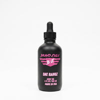 Bravo Zulu She Bangz Body Oil dropper bottle studio product shot on white background, matte black glass with pink Bravo Zulu B★Z logo, 4 fl oz / 120 mL