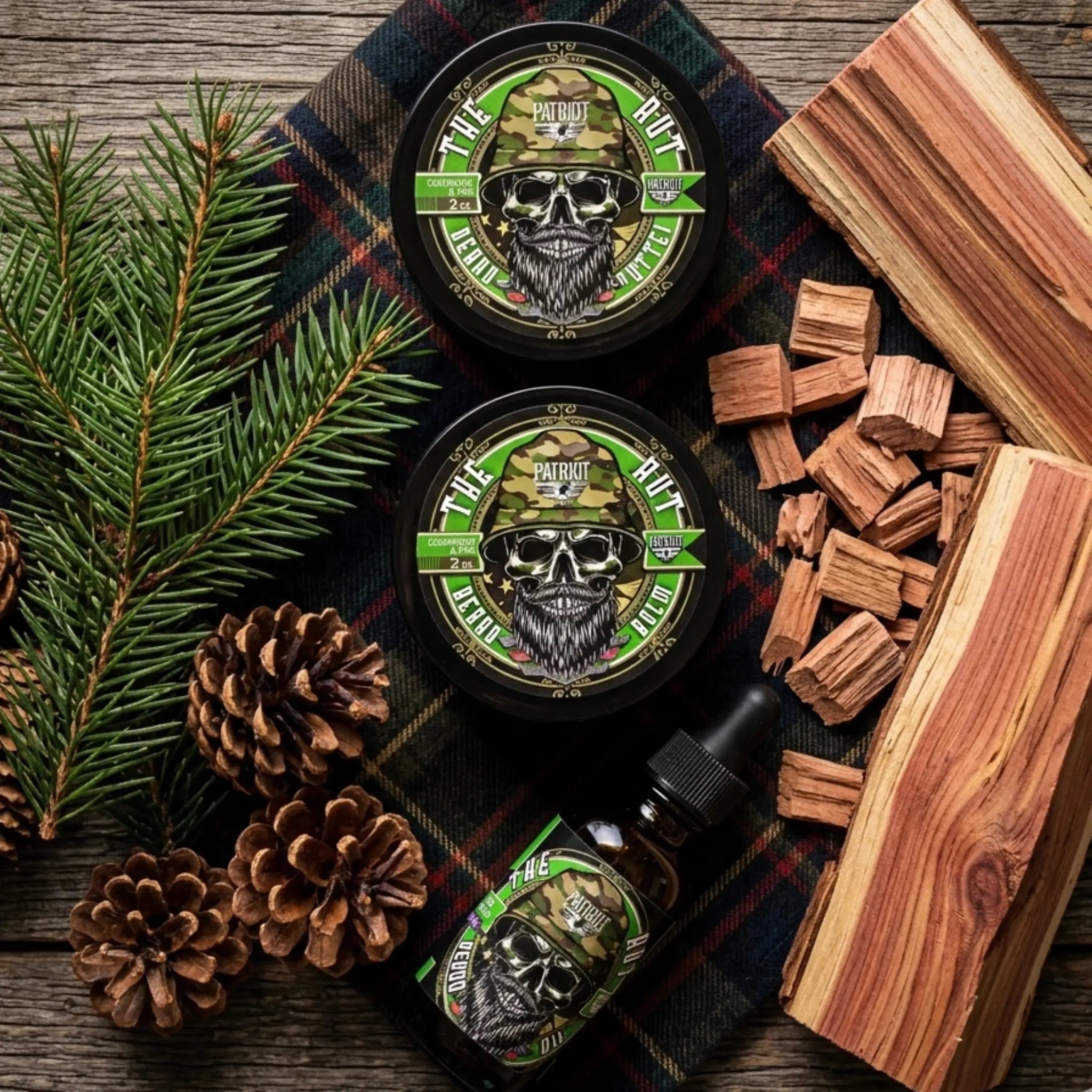 A top-down flat lay of Flagship Soap Company's "The Rut" beard balms, beard butter, and beard oil on a plaid cloth. Surrounded by fresh pine needles, pinecones, and aromatic cedar wood blocks, these products are formulated to soften the beard, prevent itching, and promote healthy skin. Scent Profile: Earthy Cedarwood and Pine.