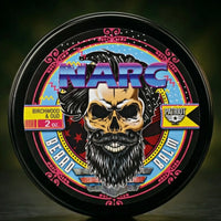 NARC Beard Balm by Flagship Soap Company featuring a Birchwood & Oud scent. The 80s synth-wave style label shows a bearded skull with big hair and neon accents. A unique, retro-themed beard conditioner for men who love a bold aesthetic.