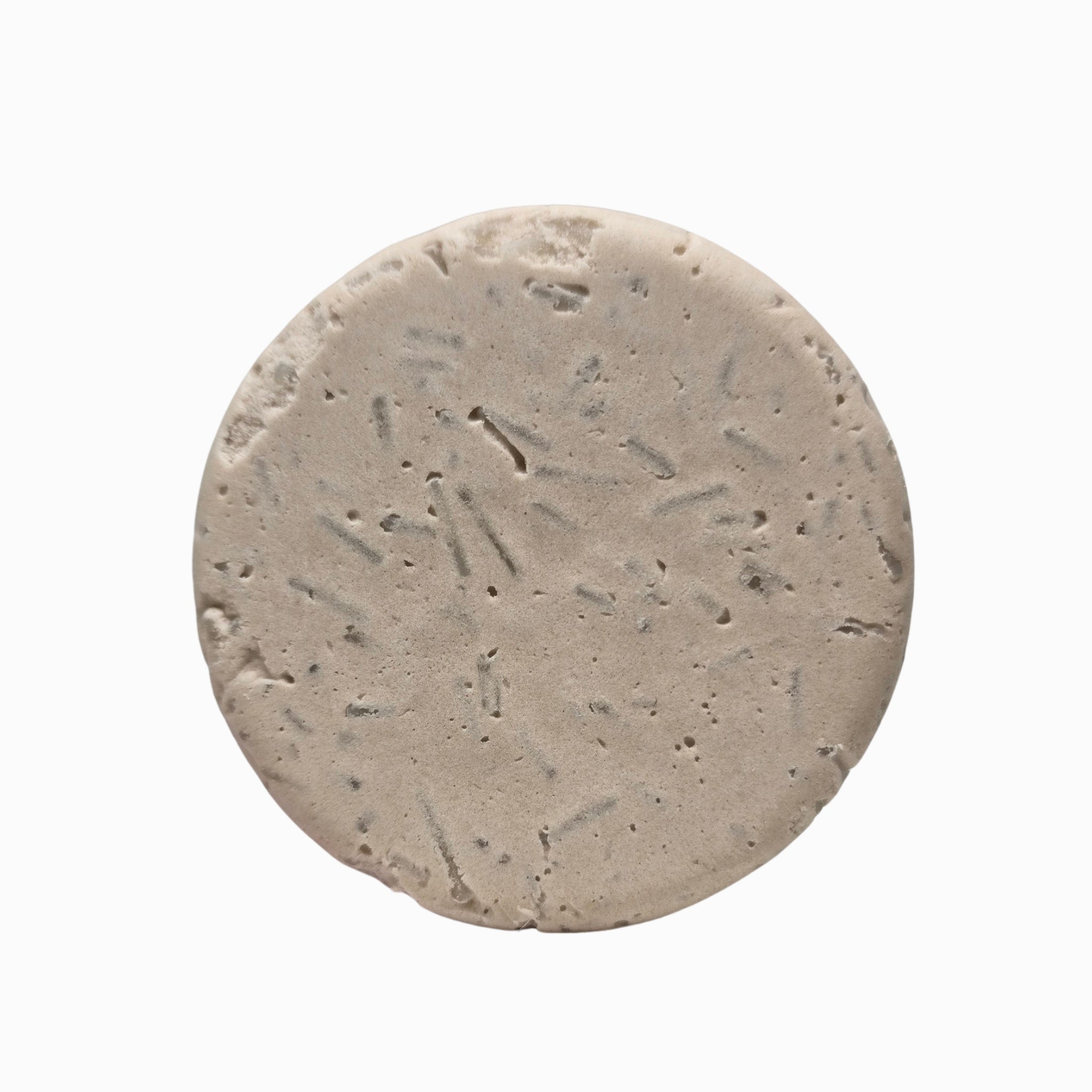 Close-up of Onyx cedarwood and vanilla natural shampoo bar puck texture