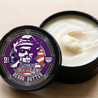 Close-up of an open tin of Flagship Soap Company’s Angry Charlie beard butter, showing the smooth, creamy whipped texture of the vanilla and cedarwood scented balm.