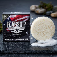Plain Jane fragrance-free beard wash puck lathering into rich creamy foam on wet dark stone