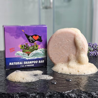 Smooth Operator lavender and lemongrass shampoo bar lathering with fresh lavender sprigs in dark bathroom