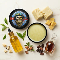 Flat lay of our top-selling Unsupervised Beard Balm with its signature masculine cologne scent, surrounded by natural shea butter, argan seeds, cocoa beans, and tea tree leaves.