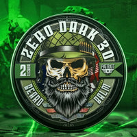 A prominent product shot of a Flagship Soap Company Zero Dark 30 beard balm tin, featuring a bearded skull in a military helmet. The tin is displayed on a textured green surface, set against a dark, night-vision-themed background with blurred figures. Spearmint leaves and coffee beans are subtly arranged at the base.
